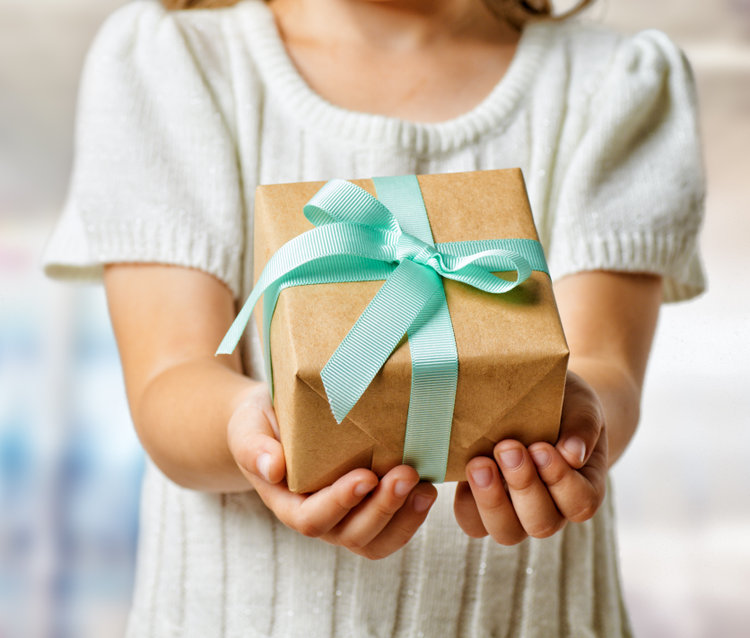 human hands holding a gift for creating a holiday gift guide